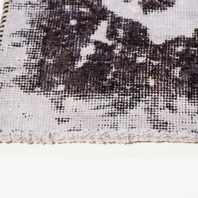 Close Up eines Persian Art Design Teppichs schwach lila Untergrund schwarz gemustert