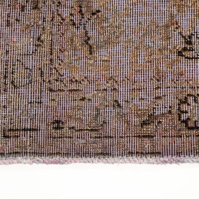 Close Up von einem Persian Art Design Teppich mit dunkel farbigem Muster auf aubergine farbenem Webgeflecht