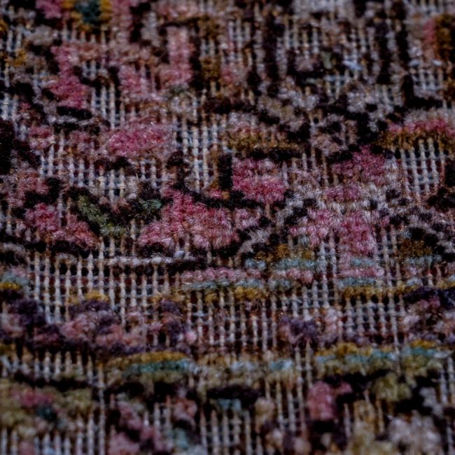 Nahaufnahme eines Persian Art Edition Teppich mit grünlichem Webfaden und braun-altrosa Muster