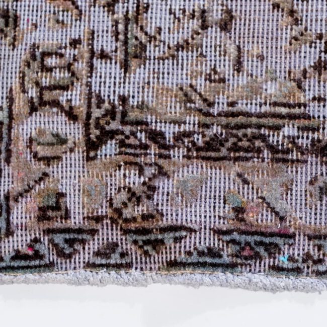 Nahaufnahme eines Persian Art Edition Teppich mit bläulichem Webfaden und braun-goldenem Muster