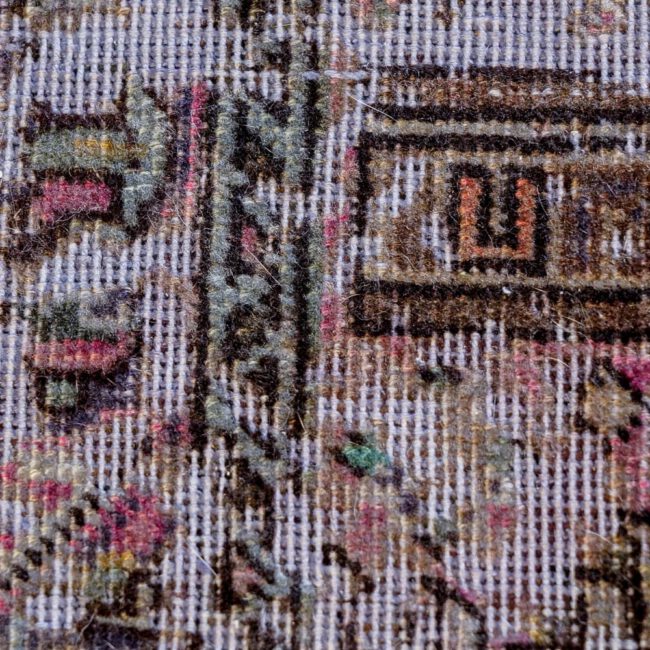 Nahaufnahme eines Persian Art Edition Teppich mit bläulichem Webfaden und braun-goldenem Muster