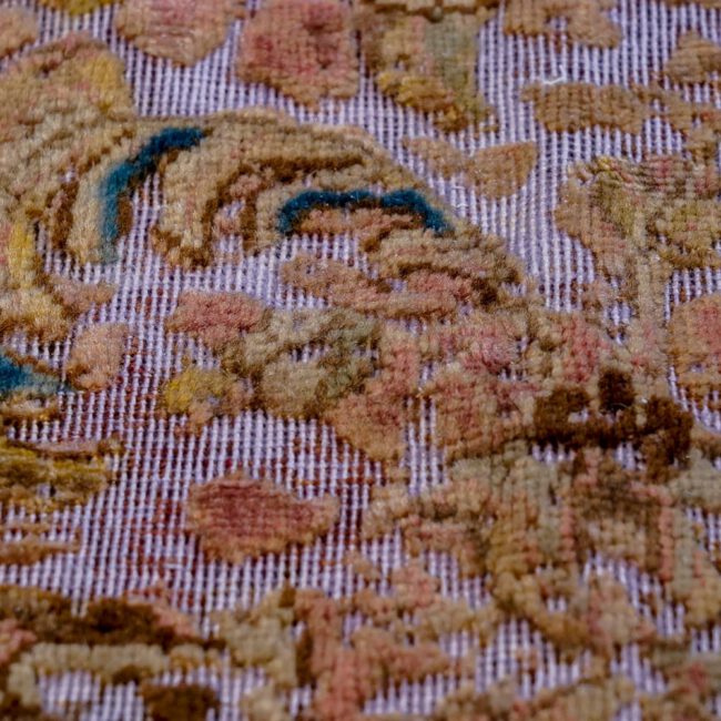 Close Up eines Persian Art Edition Teppich mit hell-lila Webfaden und buntem Muster