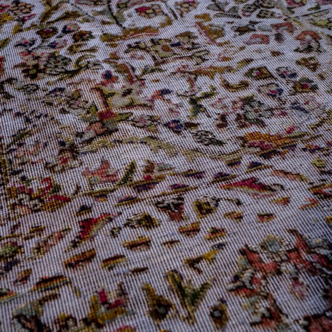 Close Up eines Persian Art Edition Teppich mit lila Webfaden und buntem Muster