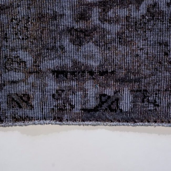 Close Up eines Persian Art Edition Teppich mit blauem Webfaden und dunklem Muster