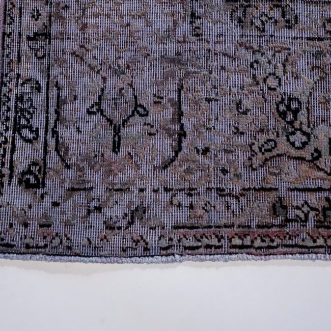 Nahaufnahme eines Persian Art Edition Teppich mit bläulichem Webfaden und schwarzem Muster